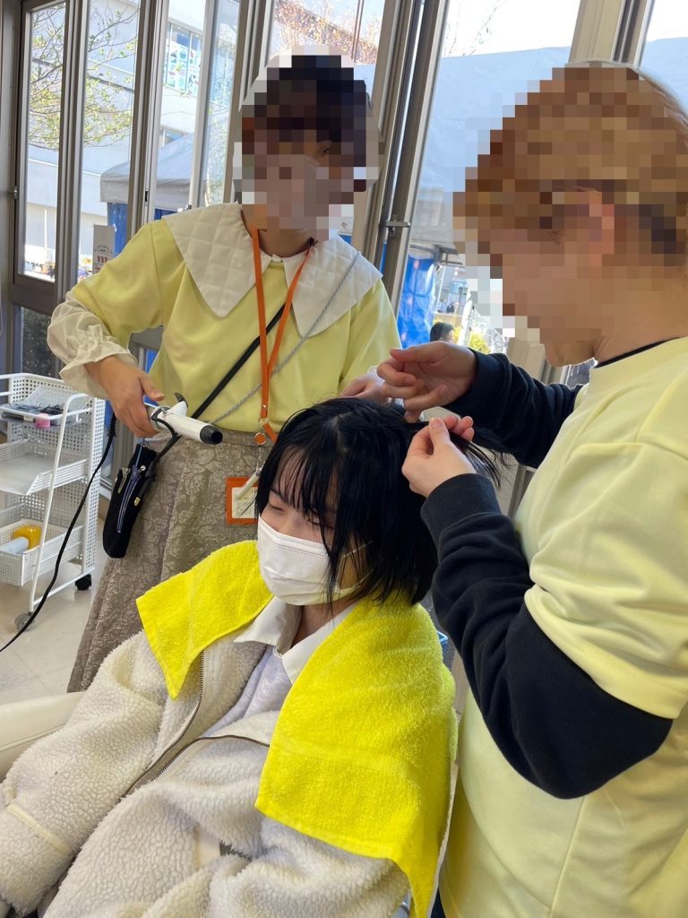 子どもが専門学生にヘアメイクをしてもらっている様子