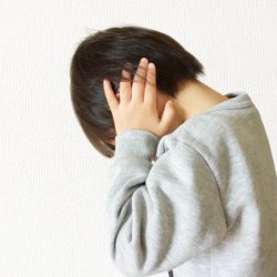 耳を塞いでいる子ども