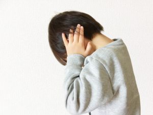 耳を塞いでいる子ども