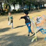公園で試行錯誤しながら手作りの凧を揚げる子ども達の様子