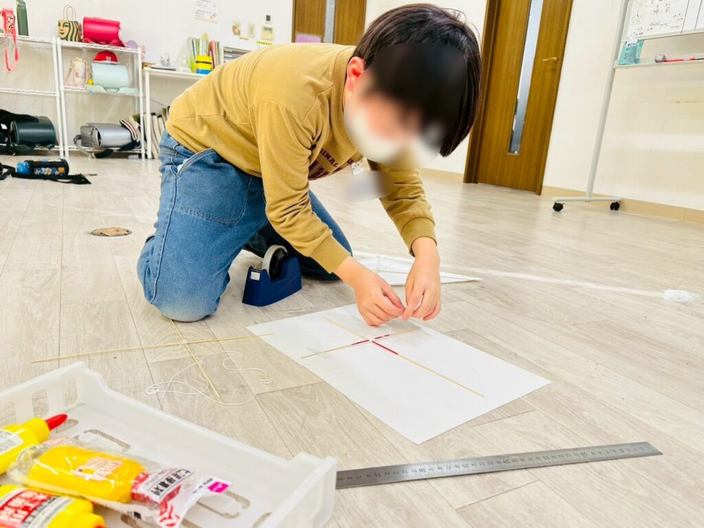 手作りの凧を制作する児童の様子